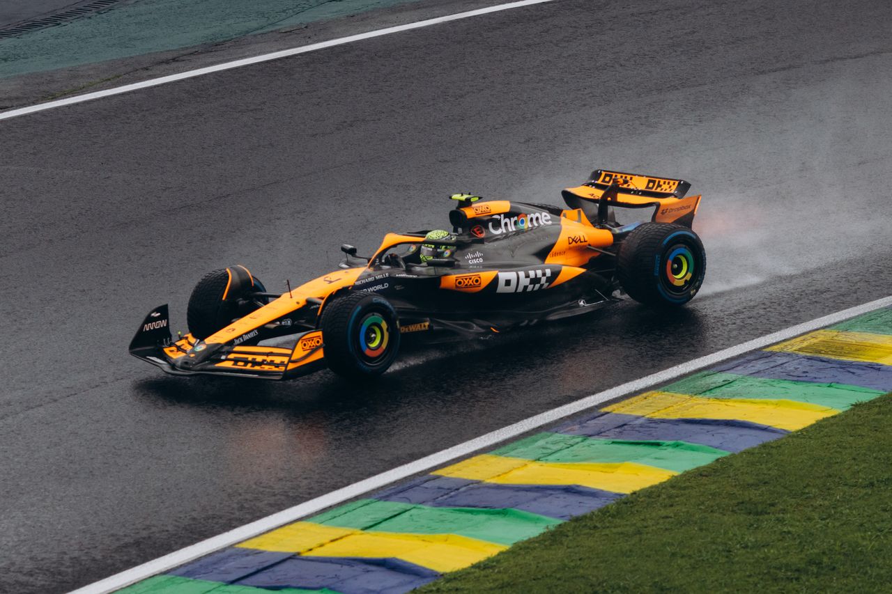 services-02 A vibrant Formula One car speeding on a wet track, showcasing dynamic motorsport action.