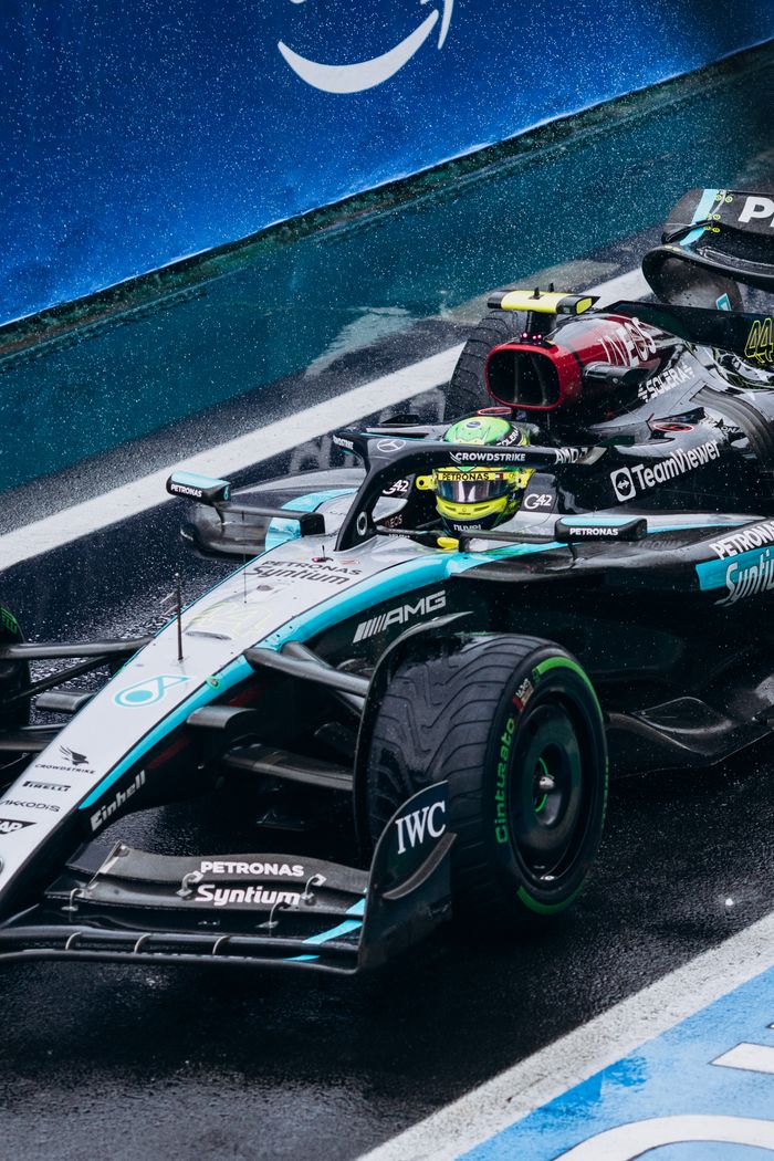 why-choose-us Close-up of a Formula One race car on wet track, showcasing speed and precision.